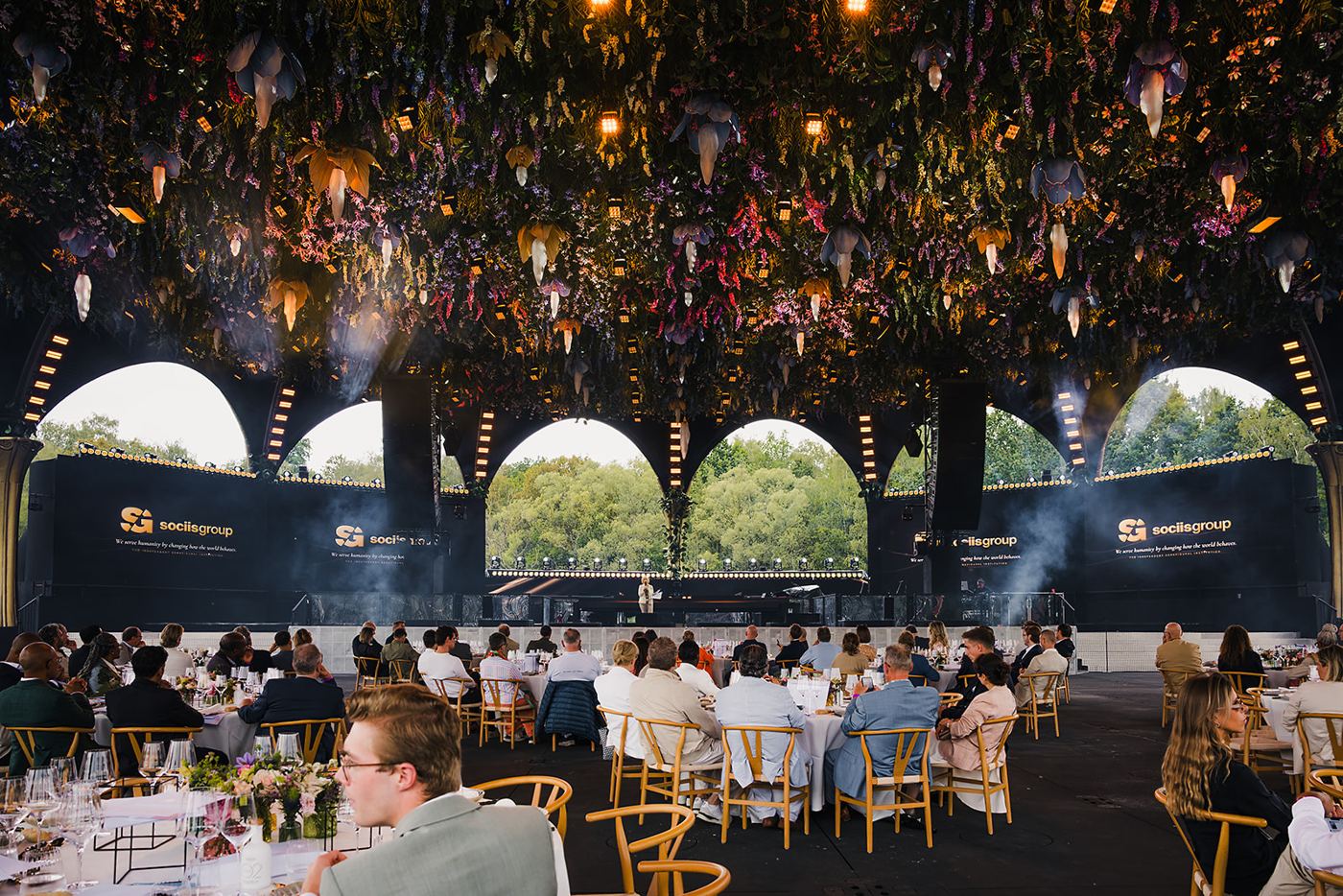Guests gathered beneath the flower-filled canopy at The 300, with sociisgroup on stage